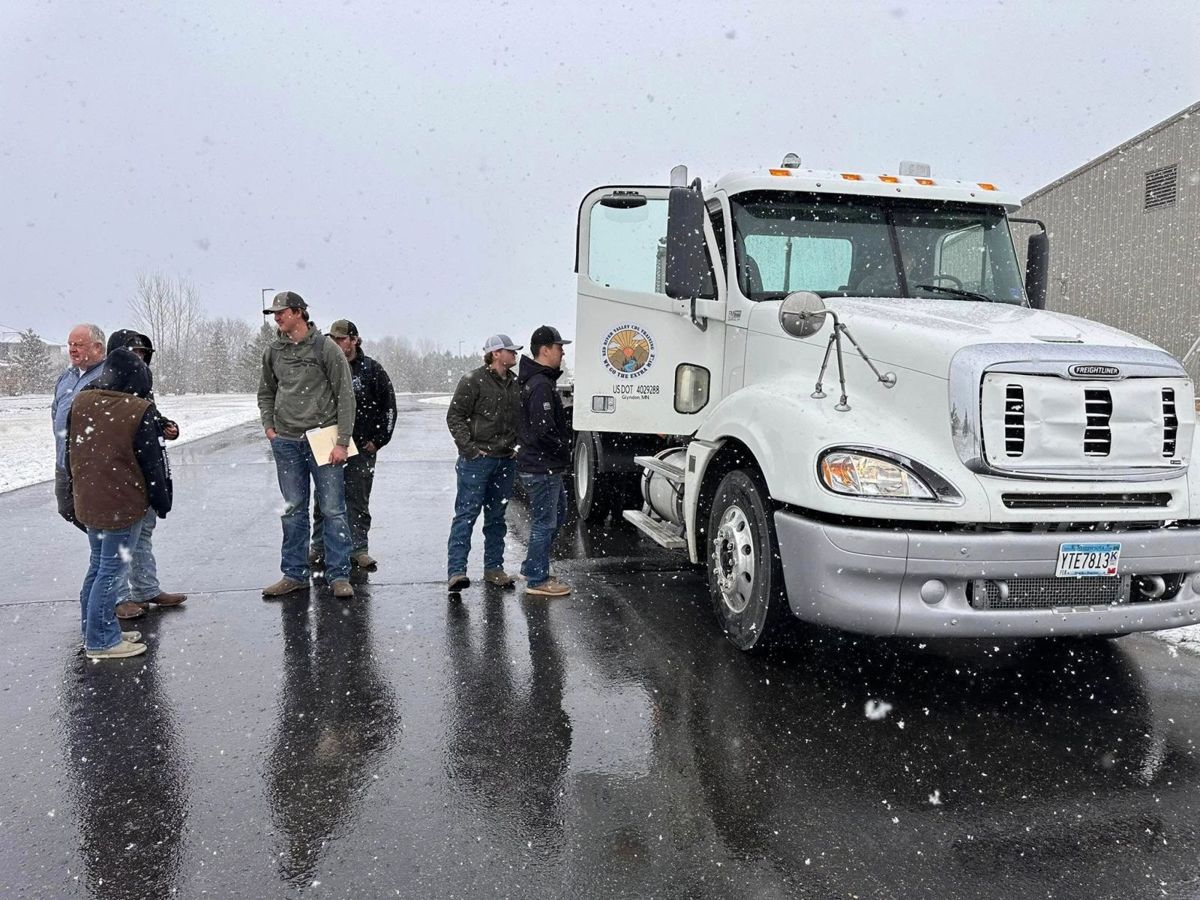 Students with the instructor beside the Red River Valley training truck in the snow
